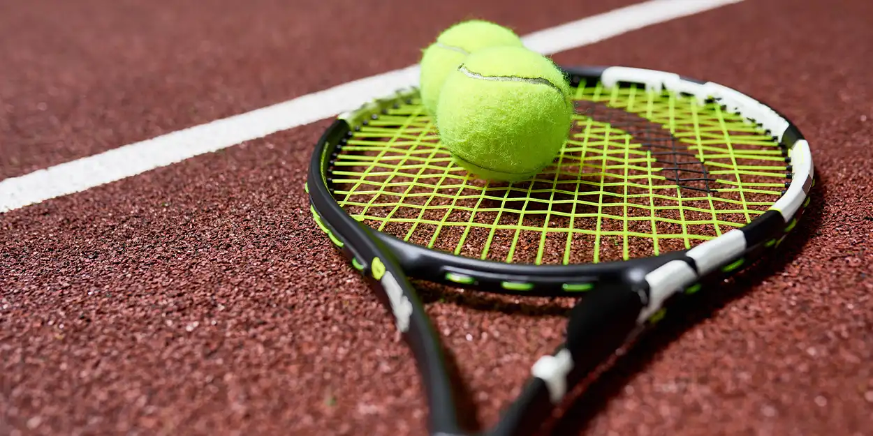 photo of tennis balls and racket